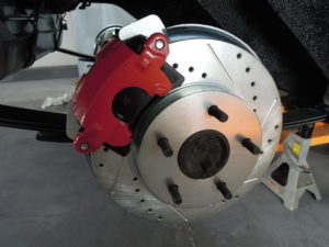 A red brake caliper and disc are on the ground.