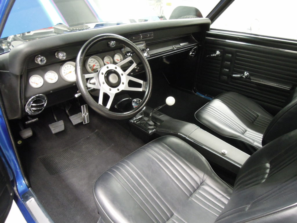 A black car with the steering wheel and dashboard.