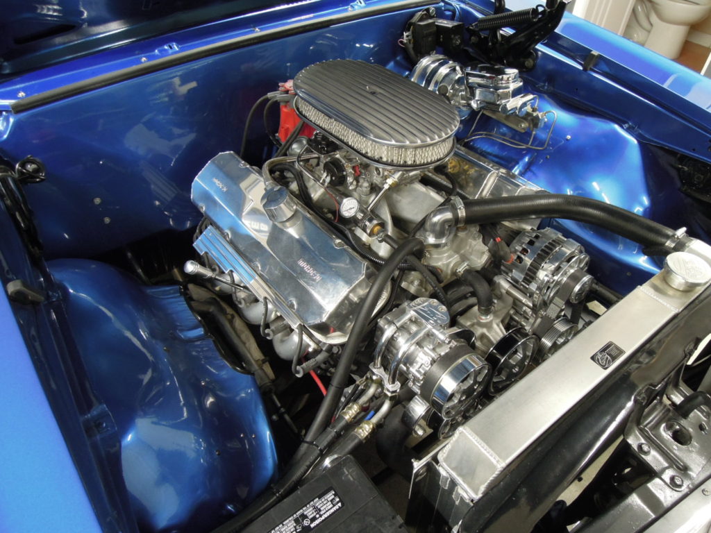 A blue car with the engine bay open.