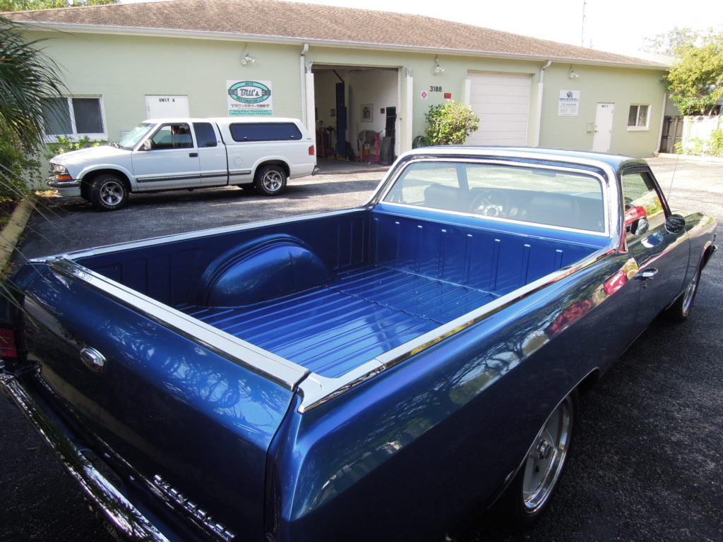 A blue truck parked in front of a building.