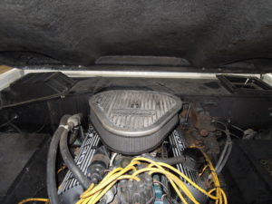 A car engine with wires attached to the top of it.