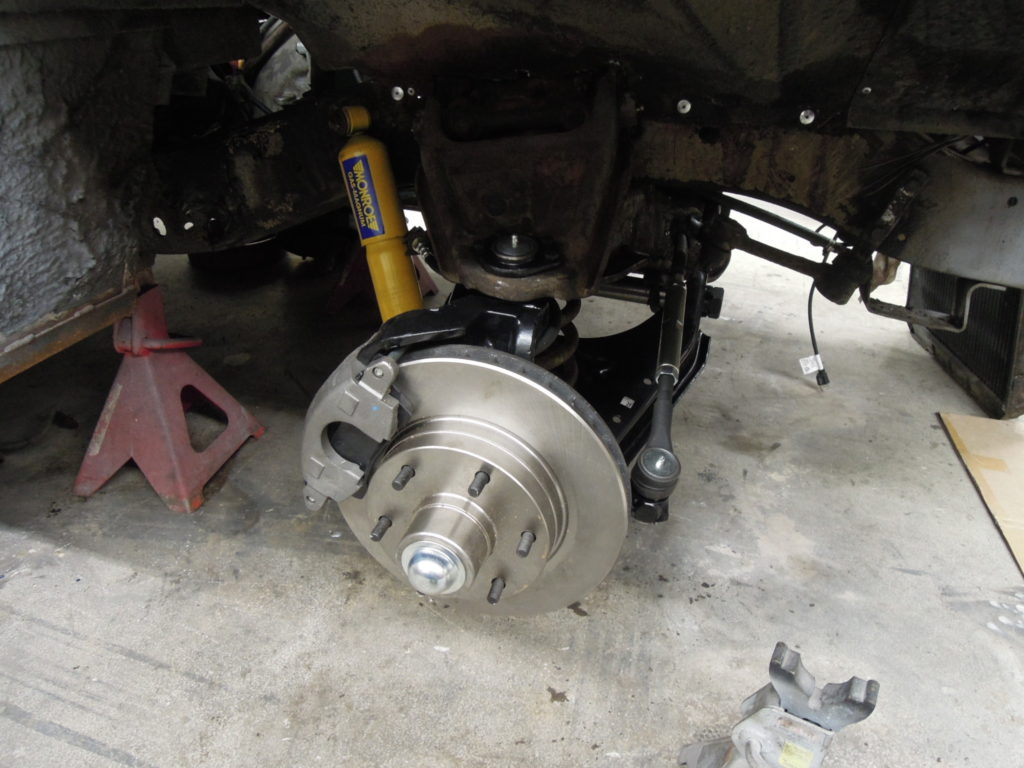 A car with the front brake disc and wheel bearing removed.