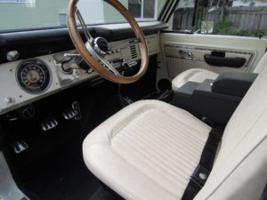 A white car with a wooden steering wheel.