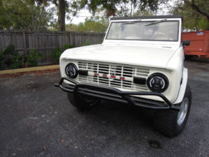 A white bronco parked in the driveway of a house.