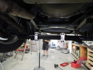 A man working in the garage on an old car.