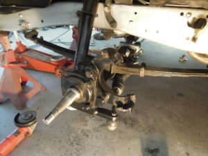 A person working on the front suspension of an off road vehicle.