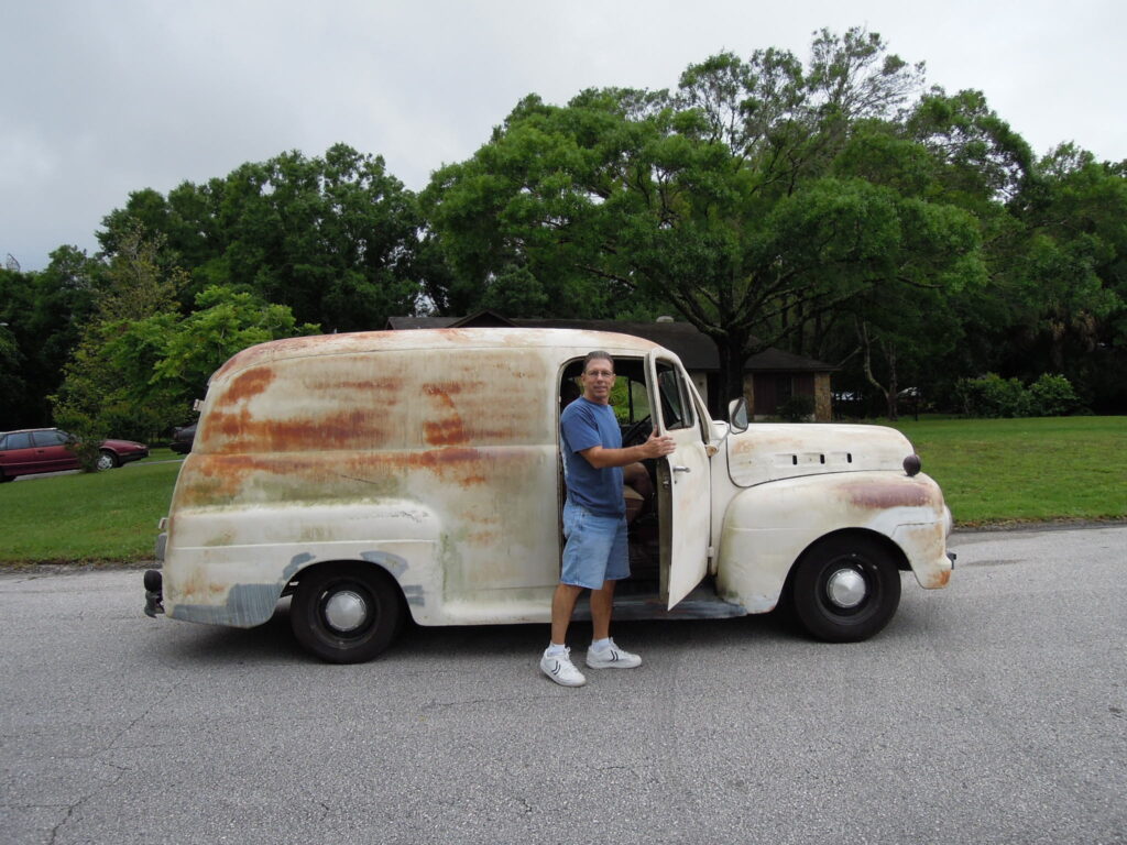 A man standing in front of an old van.