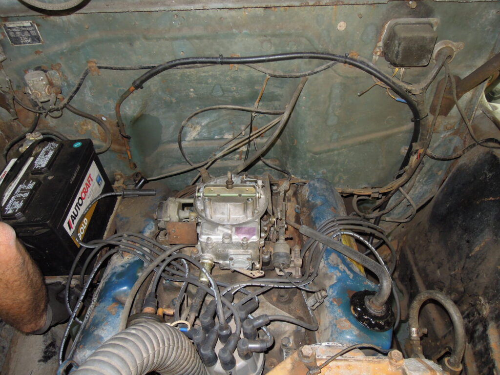 A car engine with wires and other parts in it.