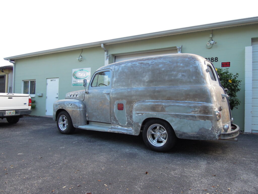 A silver truck parked in front of a building.