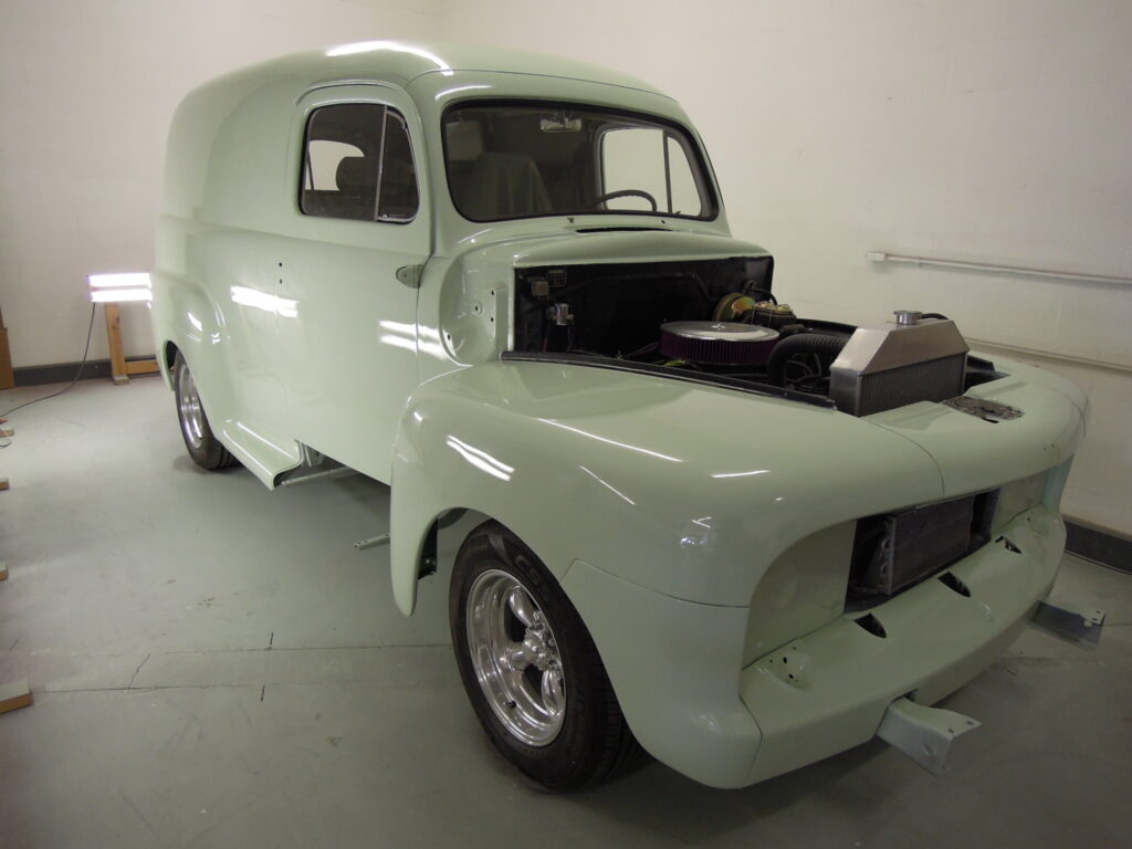 A light green truck is parked in the garage.